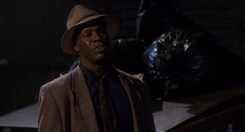 Movie still from “Predator 2” (1990), directed by Stephen Hopkins – A man wearing a hat and a suit and tie; Close Up shot, Low angle