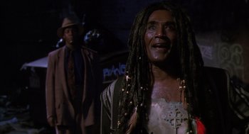 Movie still from “Predator 2” (1990), directed by Stephen Hopkins – A man with dreadlocks is standing next to another man; Close Up shot, Low angle