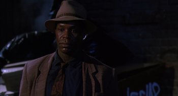Movie still from “Predator 2” (1990), directed by Stephen Hopkins – A man wearing a hat and a jacket; Close Up shot, Low angle