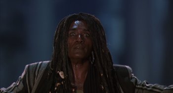Movie still from “Predator 2” (1990), directed by Stephen Hopkins – A man with dreadlocks is looking into the camera; Close Up shot, Low angle