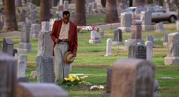 Movie still from “Predator 2” (1990), directed by Stephen Hopkins – A man standing in the middle of a cemetery; Wide shot, Low angle
