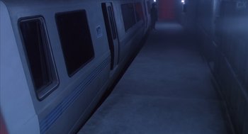 Movie still from “Predator 2” (1990), directed by Stephen Hopkins – A train is parked on the train tracks at night; Wide shot, High angle
