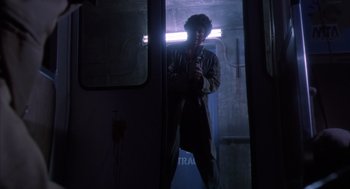 Movie still from “Predator 2” (1990), directed by Stephen Hopkins – A man standing in front of a mirror in a dark room; Wide shot, Low angle