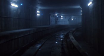 Movie still from “Predator 2” (1990), directed by Stephen Hopkins – A train track in the dark with lights on the side of it; Extreme Wide shot, High angle