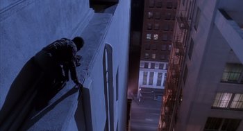 Movie still from “Predator 2” (1990), directed by Stephen Hopkins – A man standing on the side of a tall building; Extreme Wide shot, Overhead angle