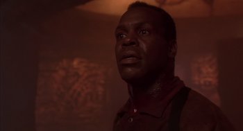 Movie still from “Predator 2” (1990), directed by Stephen Hopkins – A person wearing a red shirt; Close Up shot, Low angle