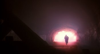 Movie still from “Predator 2” (1990), directed by Stephen Hopkins – A person is walking through a light tunnel; Extreme Wide shot, Low angle