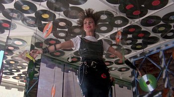 Movie still from “Pretty in Pink” (1986), directed by Howard Deutch – A woman in a white shirt and a black leather skirt; Medium shot, Low angle