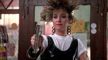 Movie still from “Pretty in Pink” (1986), directed by Howard Deutch – A woman in a black and white outfit holding a cell phone; Close Up shot, Low angle