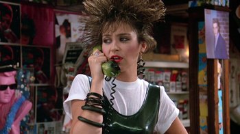 Movie still from “Pretty in Pink” (1986), directed by Howard Deutch – A woman in a wig talking on a phone; Close Up shot, Over the shoulder angle