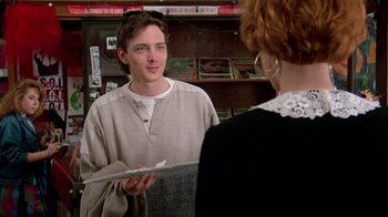 Movie still from “Pretty in Pink” (1986), directed by Howard Deutch – A young man talking to an older woman in a store; Medium shot, Over the shoulder angle