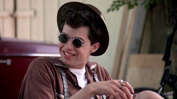 Movie still from “Pretty in Pink” (1986), directed by Howard Deutch – A young man wearing sunglasses and a hat; Close Up shot, Low angle