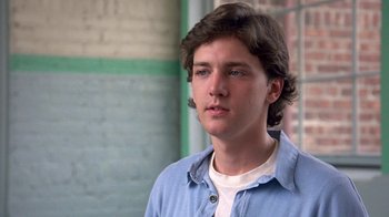 Movie still from “Pretty in Pink” (1986), directed by Howard Deutch – A young man in a blue shirt is looking at the camera; Close Up shot, Low angle
