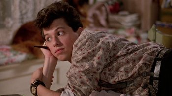 Movie still from “Pretty in Pink” (1986), directed by Howard Deutch – A young man sitting on the ground while holding a cell phone to his ear; Close Up shot, Over the shoulder angle