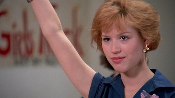 Movie still from “Pretty in Pink” (1986), directed by Howard Deutch – A young woman raises her arm in the air; Close Up shot, Low angle