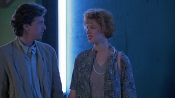 Movie still from “Pretty in Pink” (1986), directed by Howard Deutch – A woman in a dress standing next to a man in a suit; Medium shot, Over the shoulder angle