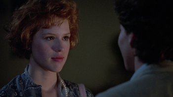 Movie still from “Pretty in Pink” (1986), directed by Howard Deutch – A woman with red hair and a pearl necklace is looking at a man with red hair; Close Up shot, Over the shoulder angle