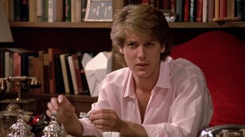 Movie still from “Pretty in Pink” (1986), directed by Howard Deutch – A man in a pink shirt is sitting at a table; Close Up shot, Over the shoulder angle