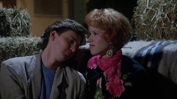 Movie still from “Pretty in Pink” (1986), directed by Howard Deutch – A man and a woman sitting next to each other on a couch; Medium shot, Low angle