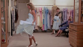 Movie still from “Pretty in Pink” (1986), directed by Howard Deutch – A woman in a white dress is walking in a store; Wide shot, Over the shoulder angle