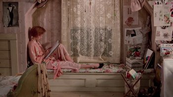 Movie still from “Pretty in Pink” (1986), directed by Howard Deutch – A woman sitting on a bed reading a book; Wide shot, High angle