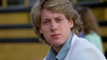 Movie still from “Pretty in Pink” (1986), directed by Howard Deutch – A man with long blonde hair wearing a blue shirt; Close Up shot, Over the shoulder angle