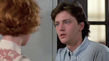 Movie still from “Pretty in Pink” (1986), directed by Howard Deutch – A young man looking into a mirror while standing up; Close Up shot, Over the shoulder angle