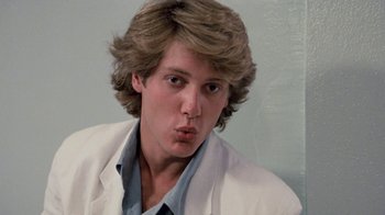 Movie still from “Pretty in Pink” (1986), directed by Howard Deutch – A young man in a white lab coat and blue shirt; Close Up shot, Low angle