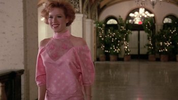 Movie still from “Pretty in Pink” (1986), directed by Howard Deutch – A woman in a pink dress standing in an indoor setting; Medium shot, Low angle
