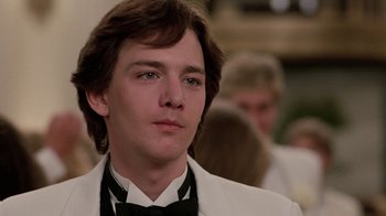 Movie still from “Pretty in Pink” (1986), directed by Howard Deutch – A man in a white suit and a black bow tie; Close Up shot, Low angle