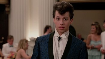 Movie still from “Pretty in Pink” (1986), directed by Howard Deutch – A young man in a blue suit and a black tie; Close Up shot, Low angle