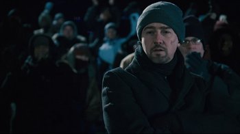 Movie still from “Pride and Glory” (2008), directed by Gavin O'Connor – A man wearing a black coat and a green hat; Medium shot, Over the shoulder angle