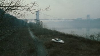 Movie still from “Pride and Glory” (2008), directed by Gavin O'Connor – A car parked on top of a hill near a river; Extreme Wide shot, High angle