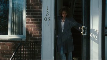 Movie still from “Pride and Glory” (2008), directed by Gavin O'Connor – A woman is standing in front of the door of a house; Wide shot, High angle
