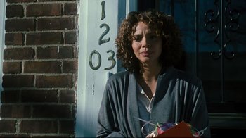 Movie still from “Pride and Glory” (2008), directed by Gavin O'Connor – A woman standing in front of a brick building; Medium shot, Over the shoulder angle