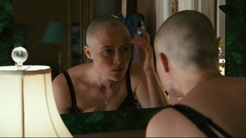 Movie still from “Pride and Glory” (2008), directed by Gavin O'Connor – A woman with a shaved head looking in the mirror; Close Up shot, Over the shoulder angle