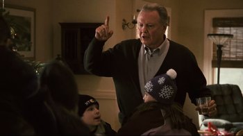 Movie still from “Pride and Glory” (2008), directed by Gavin O'Connor – An older man holding a young child and pointing at something; Medium shot, Over the shoulder angle