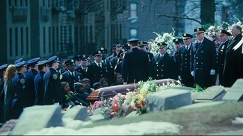 Movie still from “Pride and Glory” (2008), directed by Gavin O'Connor – A group of men in uniform standing next to a casket; Wide shot, High angle