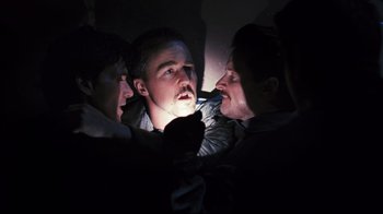 Movie still from “Pride and Glory” (2008), directed by Gavin O'Connor – A group of people in the dark with a flashlight; Close Up shot, Low angle