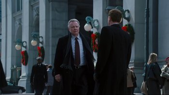 Movie still from “Pride and Glory” (2008), directed by Gavin O'Connor – A man in a suit and tie standing next to another man in a suit and tie; Medium shot, Over the shoulder angle