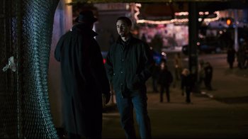Movie still from “Pride and Glory” (2008), directed by Gavin O'Connor – A man standing next to another man on the sidewalk; Medium shot, Over the shoulder angle