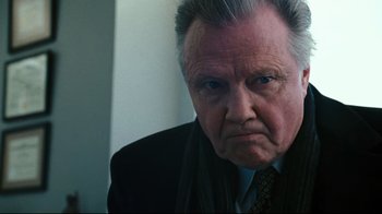Movie still from “Pride and Glory” (2008), directed by Gavin O'Connor – An older man in a suit and tie looking at the camera; Close Up shot, Low angle