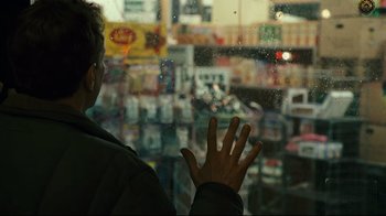 Movie still from “Pride and Glory” (2008), directed by Gavin O'Connor – A man standing in front of a store looking out of a window; Close Up shot, Over the shoulder angle