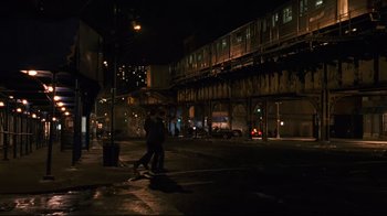 Movie still from “Pride and Glory” (2008), directed by Gavin O'Connor – Two people walking on the sidewalk in the dark; Wide shot, High angle