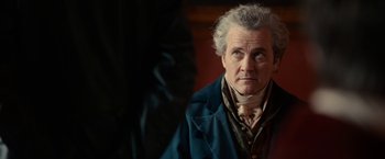 Movie still from “Pride and Prejudice and Zombies” (2016), directed by Burr Steers – An older man in a blue jacket looking at the camera; Close Up shot, Over the shoulder angle