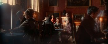 Movie still from “Pride and Prejudice and Zombies” (2016), directed by Burr Steers – A group of people sitting at a table in front of a window; Wide shot, Over the shoulder angle