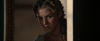 Movie still from “Pride and Prejudice and Zombies” (2016), directed by Burr Steers – A beautiful young woman with a braid standing next to a wall; Close Up shot, Over the shoulder angle