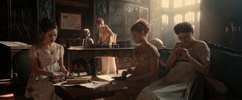 Movie still from “Pride and Prejudice and Zombies” (2016), directed by Burr Steers – A group of people sitting at a table in a room; Wide shot, High angle