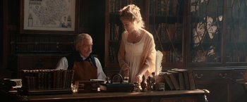 Movie still from “Pride and Prejudice and Zombies” (2016), directed by Burr Steers – An older man and a young woman in an old - fashioned library; Medium shot, Over the shoulder angle