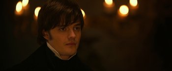Movie still from “Pride and Prejudice and Zombies” (2016), directed by Burr Steers – A young man in a black shirt is looking at the camera; Close Up shot, Over the shoulder angle